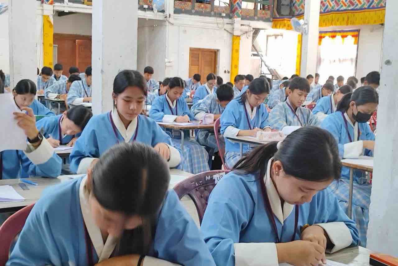 A close-up view of students writing during an examination at PHSS